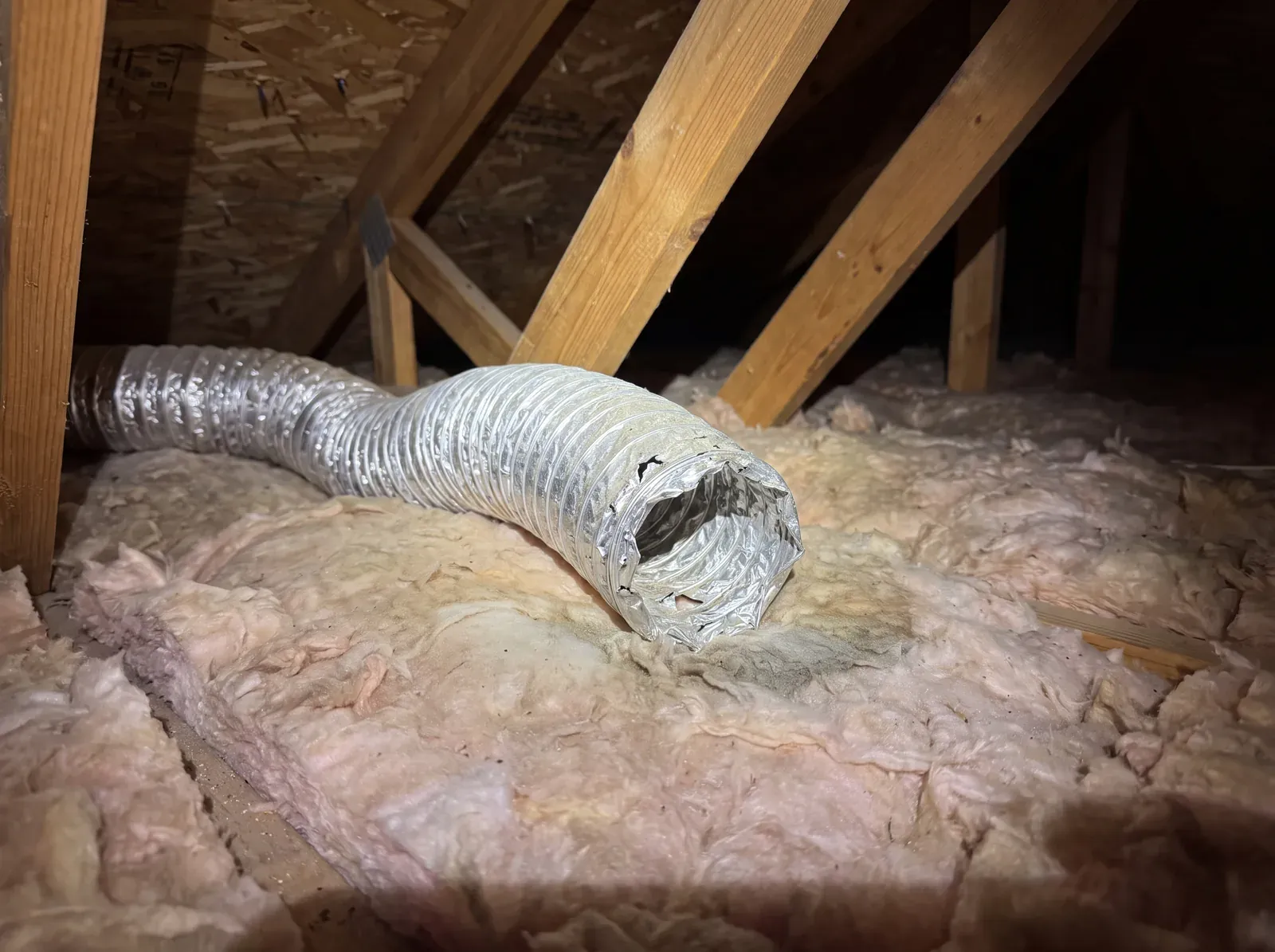 Incorrect: flexible exhaust duct ending open in attic insulation with no exterior vent connection