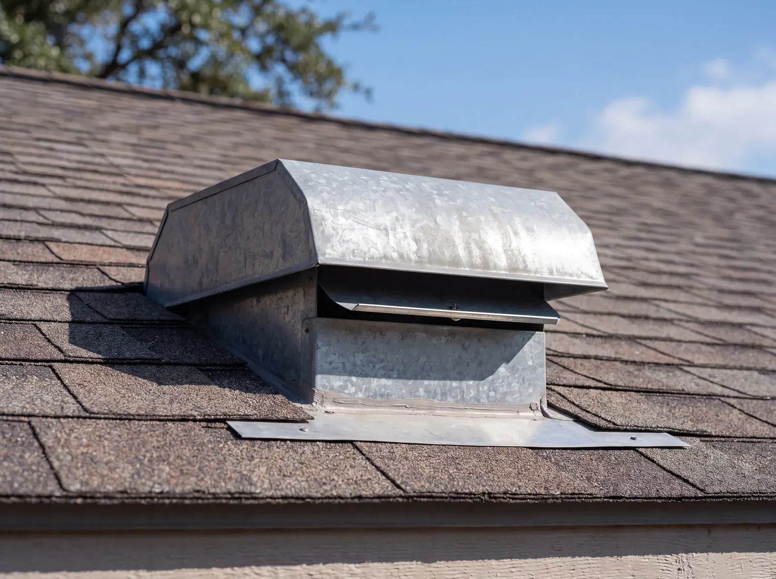 Correct: bathroom exhaust duct terminating at a dampered galvanized vent cap on the roof