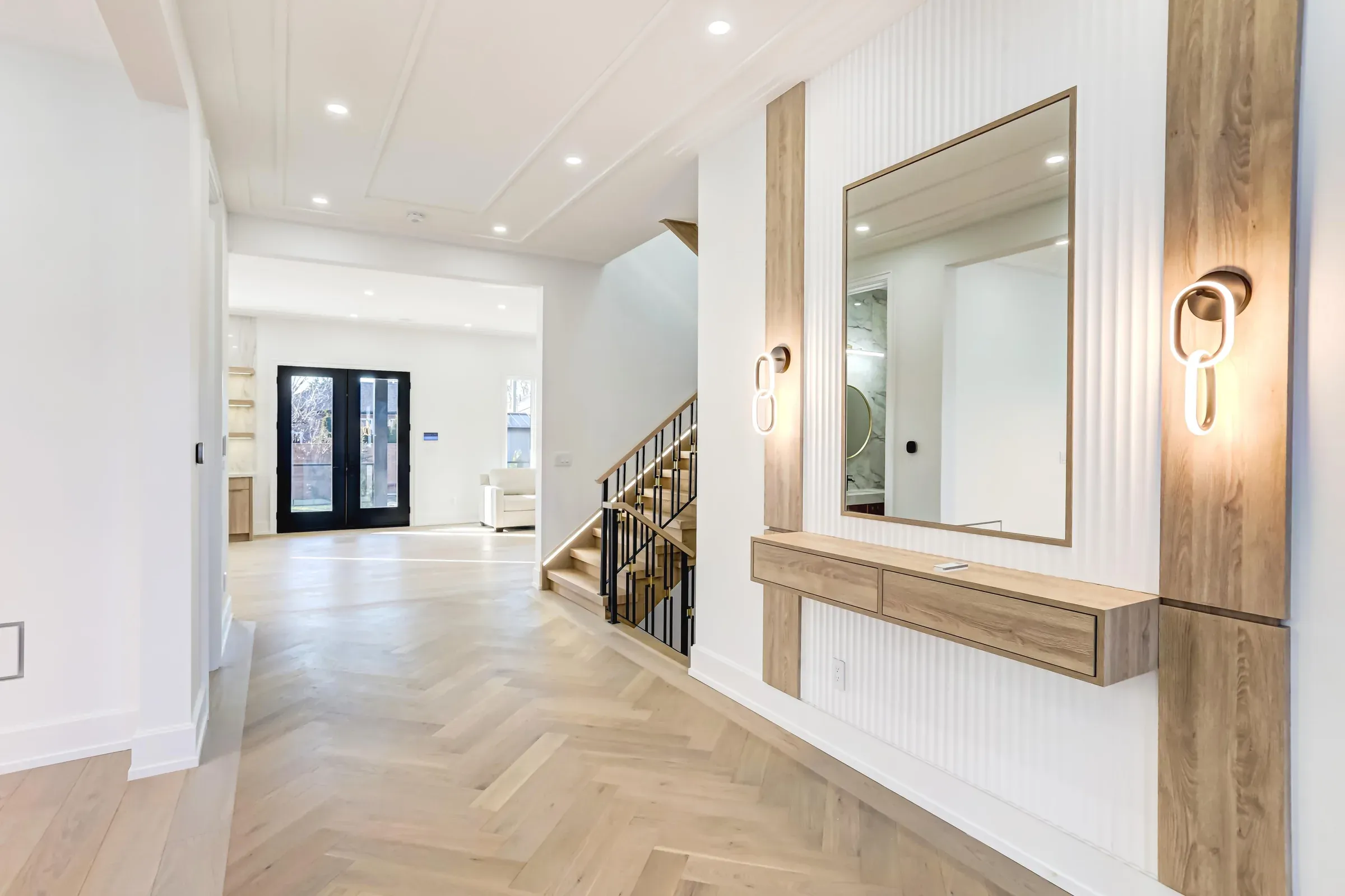 Finished Austin whole-home remodel with a white oak entry console, herringbone floors, and the open stair hall beyond