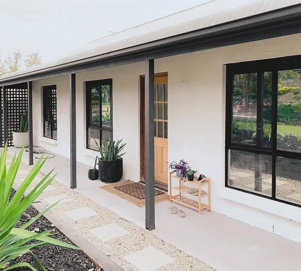 Exterior remodel in Bouldin Creek, Austin, TX with white painted brick and black-framed windows