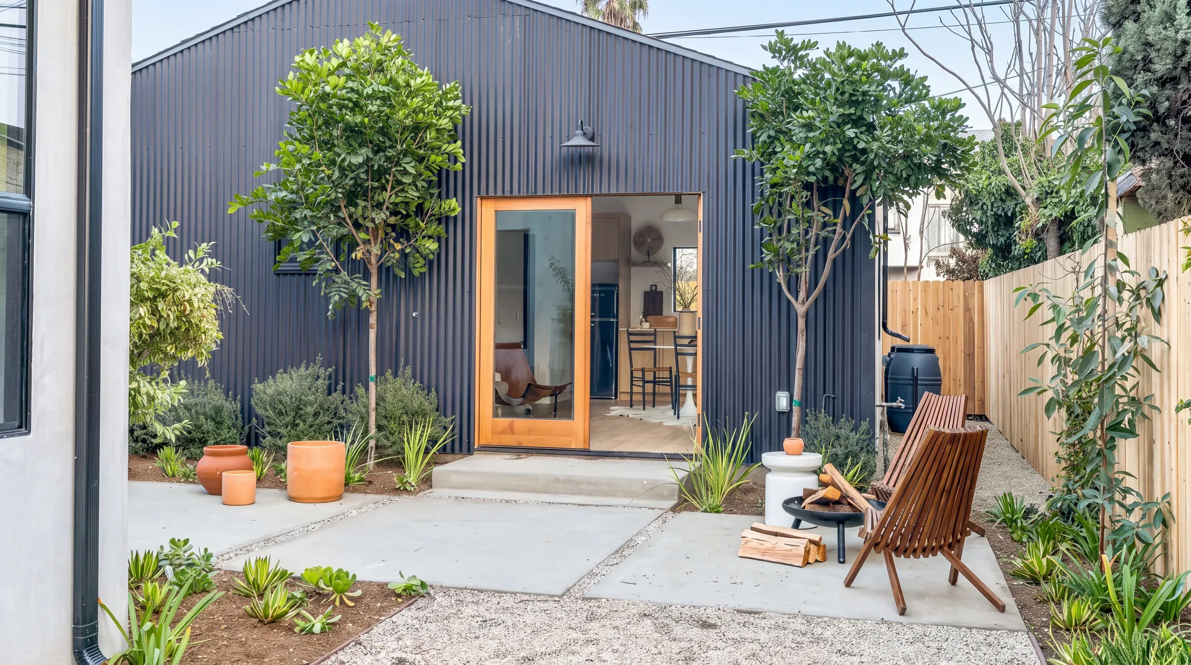 Detached ADU in Austin with dark vertical siding and a planted courtyard