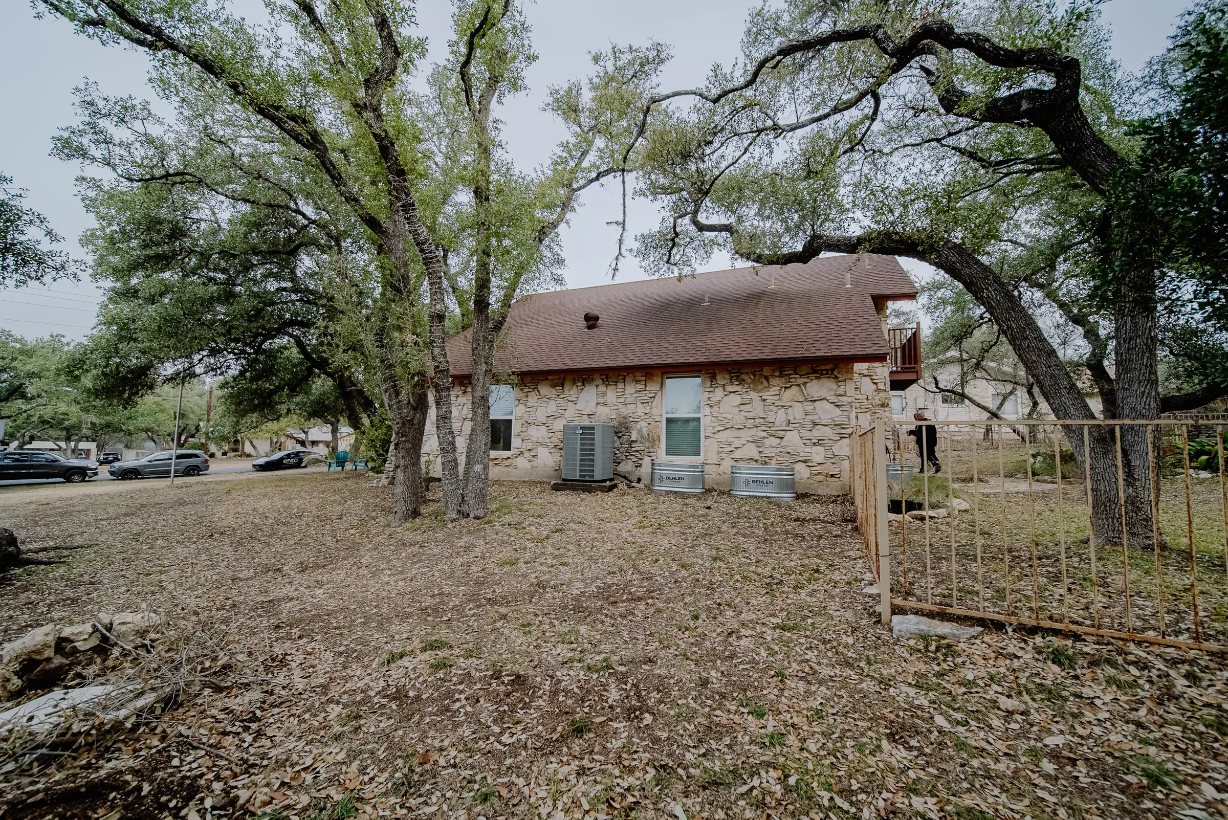 The house before the addition: single-storey stone cottage under live oaks