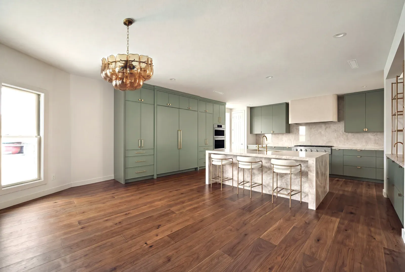 Kitchen remodel in Zilker, Austin, TX with sage green cabinetry and a walnut floor