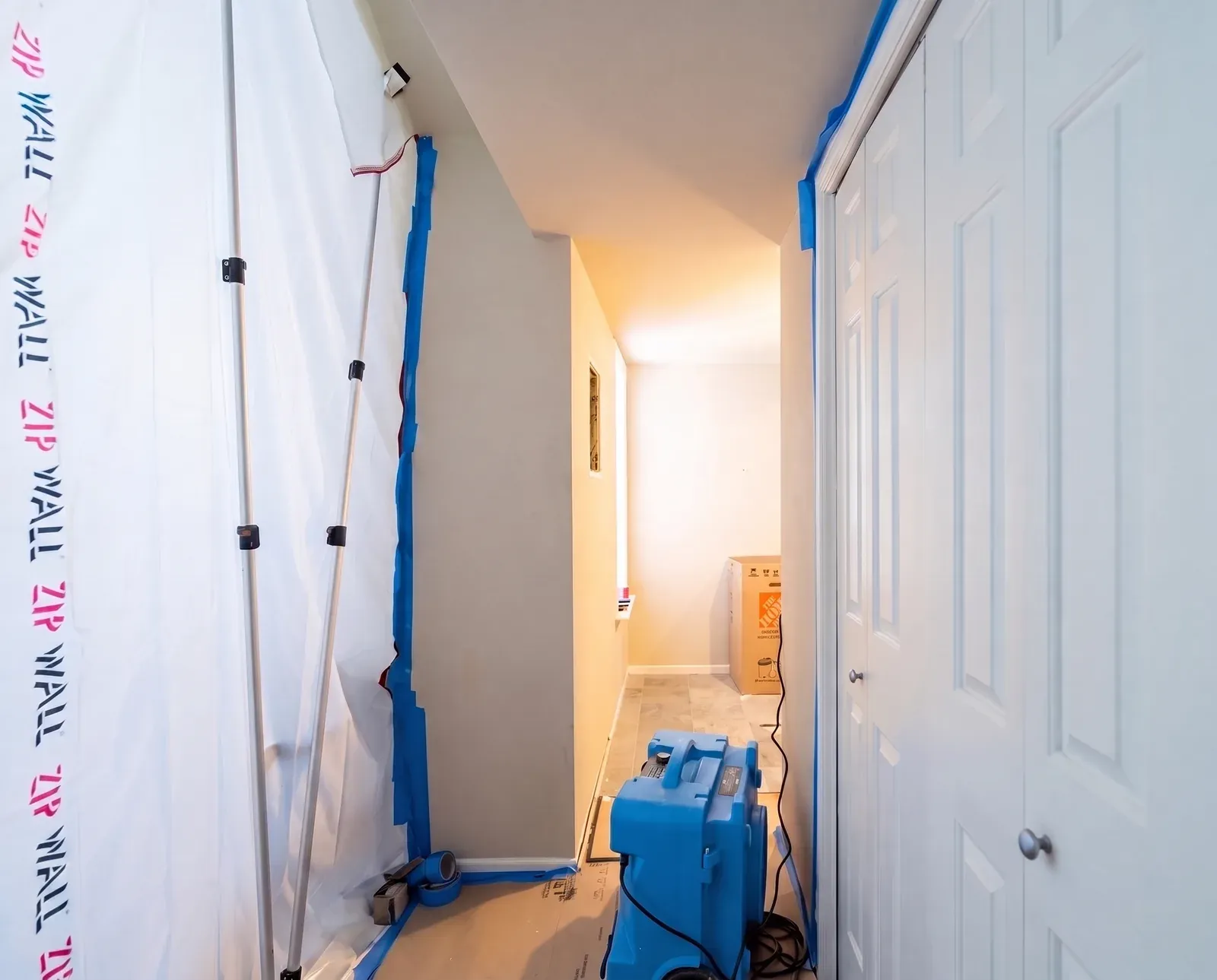 Sealed dust barrier and HEPA air scrubber set up at an Enso job site in Austin